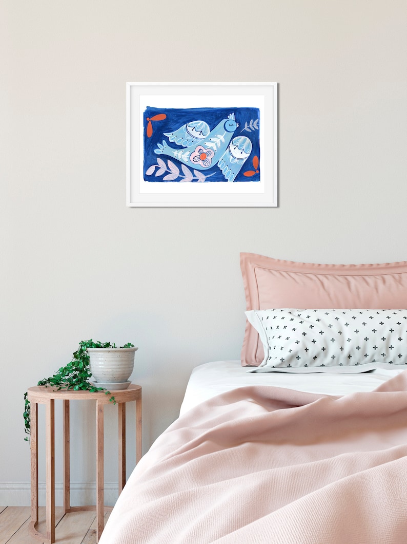Pode incluir: Uma impress&atilde;o emoldurada de um p&aacute;ssaro azul com uma flor e folhas sobre um fundo azul escuro. O p&aacute;ssaro &eacute; estilizado e tem um toque caprichoso.