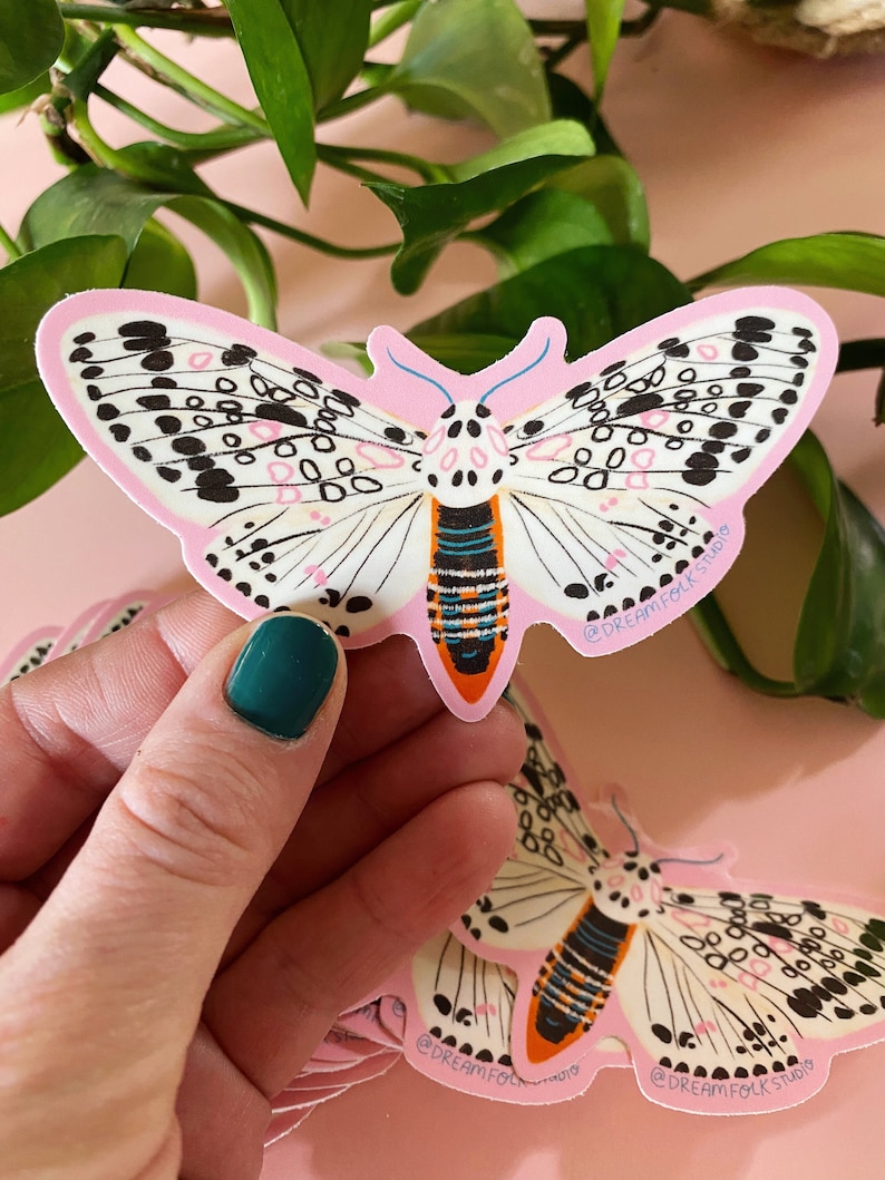 black and white leopard moth sticker. pink background.