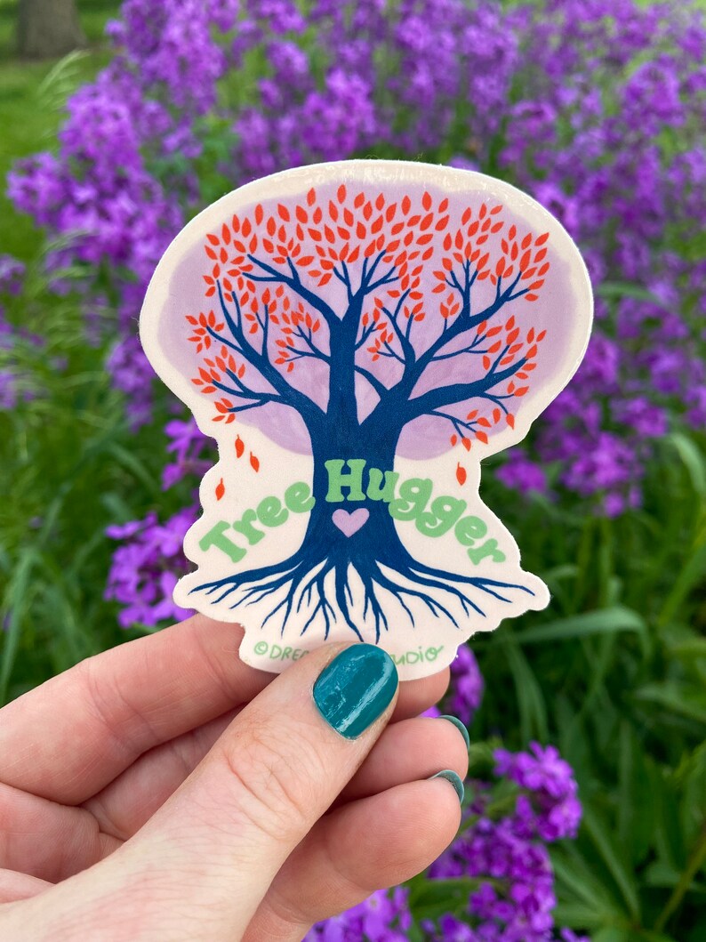 May include: A sticker with a blue tree with red leaves and a green heart. The text "Tree Hugger" is written around the tree in green letters. The sticker is on a white background.