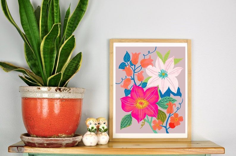 May include: A framed print of a floral illustration featuring pink, white, and orange flowers with green leaves on a light purple background.