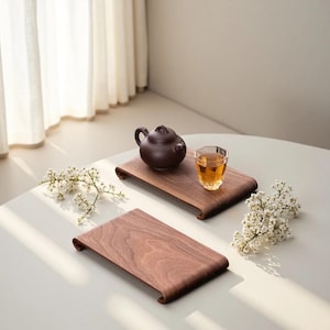 Puede incluir: Un juego de tres tazas de cerámica con un acabado moteado y mate. Las tazas son de color crema, gris claro y gris oscuro. Cada taza tiene un diseño simple y minimalista.