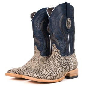 Puede incluir: Botas de vaquero con un patrón texturizado marrón claro y negro en el pie y una parte superior de cuero azul marino. Las botas tienen una puntera cuadrada y un ribete blanco.