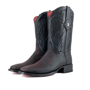 Könnte beinhalten: Ein Paar schwarze Cowboy-Stiefel mit roten Akzenten. Die Stiefel haben ein strukturiertes Design am unteren Teil und dekorative Nähte am oberen Schaft. Das Innenfutter ist rot.