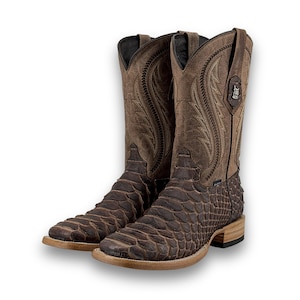 Könnte beinhalten: Ein Paar braune Cowboy-Stiefel mit einem strukturierten, schuppenartigen Muster am Fuß und einem glatten, bestickten Schaft. Die Stiefel haben eine quadratische Spitze und eine hellfarbige Sohle.
