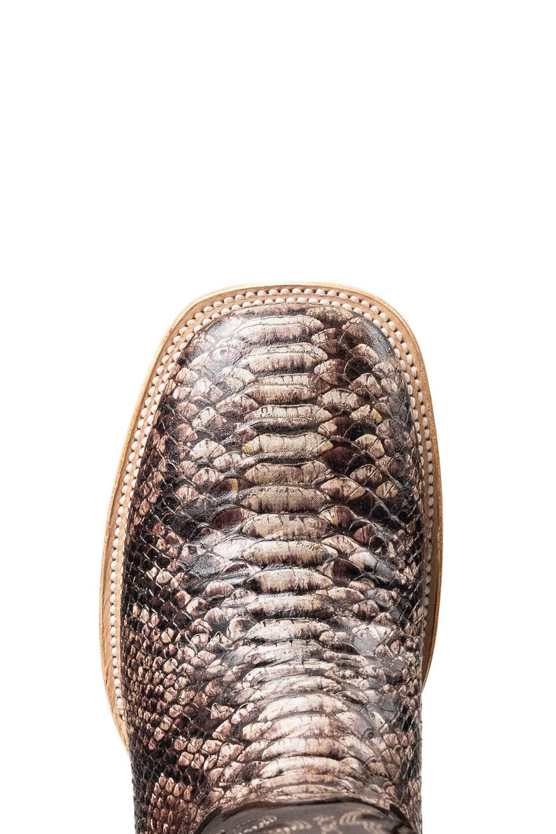 May include: Close-up of a square-toe boot with a snakeskin pattern in shades of brown, tan, and gray. The boot has a light-colored leather trim around the toe.
