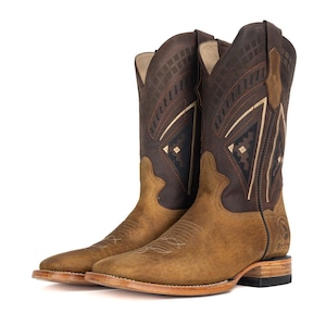 May include: A pair of brown leather cowboy boots. The boots have a square toe and a stacked heel. The shaft is decorated with geometric patterns in darker brown and tan. The boots are set against a white background.
