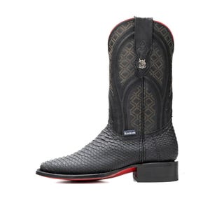 K&ouml;nnte beinhalten: Schwarzer Cowboy-Stiefel mit strukturiertem Schlangenmuster am Fu&szlig; und dekorativ gen&auml;hter Schaft. Der Stiefel hat eine rote Sohle und ein kleines Metall-Emblem. Der Markenname "Rockem" ist sichtbar.