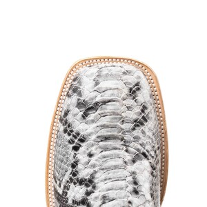 May include: Close-up of a square-toe boot with a snakeskin pattern in shades of gray and black. The boot has a light brown leather trim around the toe and a light brown sole.