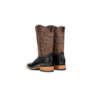 May include: A pair of brown and black cowboy boots. The boots feature a square toe, a black leather foot, and a brown leather upper with decorative stitching. The heel is made of light-coloured wood. The boots are set against a white background.