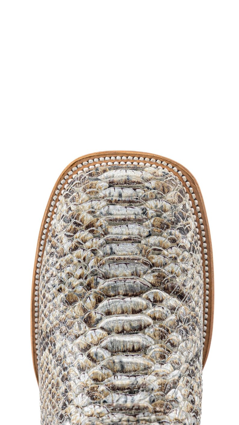 May include: Close-up of a western-style boot toe. The boot features a snakeskin pattern in shades of gray, brown, and cream. The toe is square with a light brown leather trim and a decorative stitch pattern.