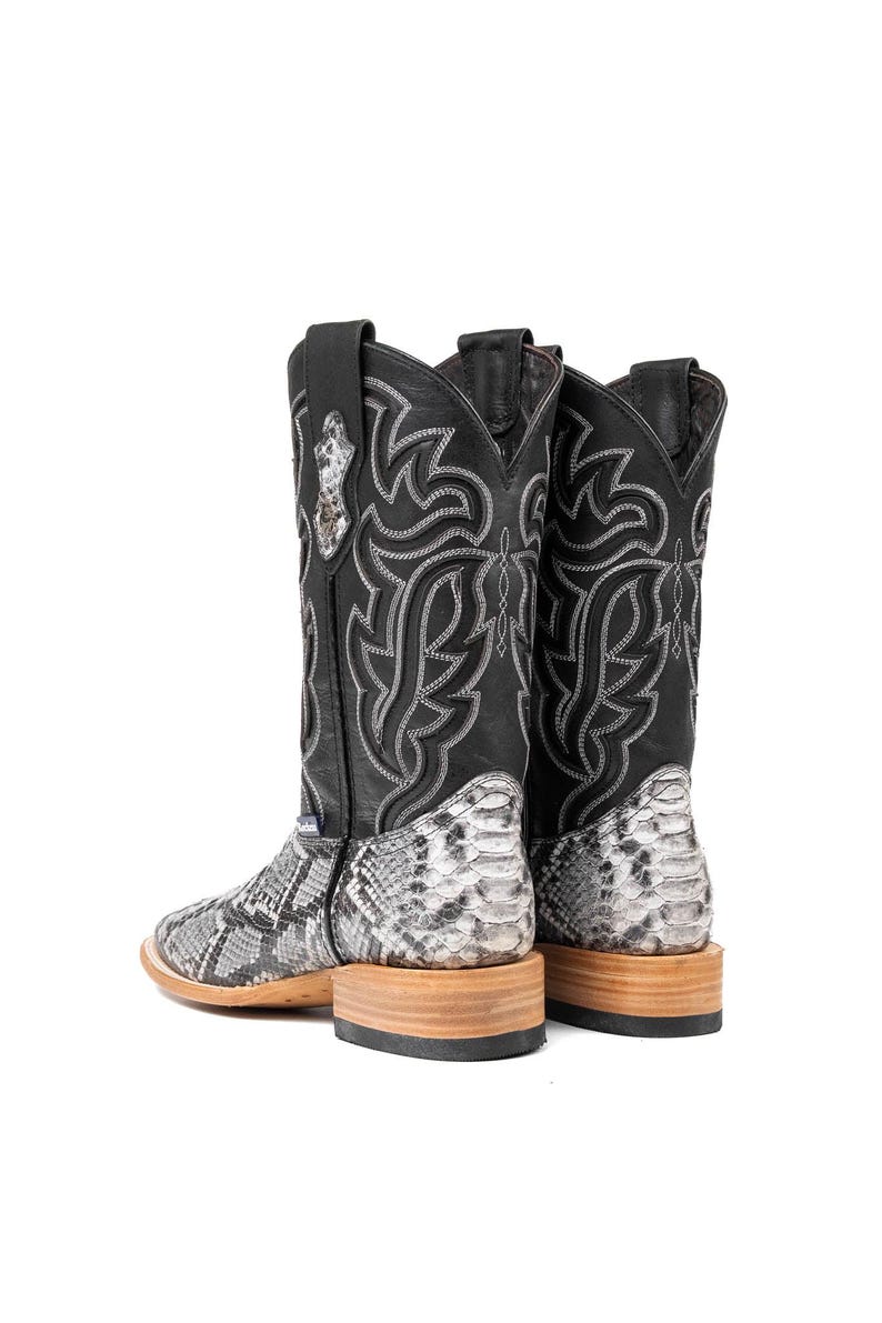 May include: A pair of black cowboy boots with a snakeskin pattern on the lower part and a decorative stitched design. The boots have a square toe and a wooden sole.