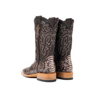 May include: A pair of brown cowboy boots with a snakeskin pattern on the lower portion and decorative stitching on the upper shaft. The boots have a square toe and a stacked heel, showcasing a classic Western style.