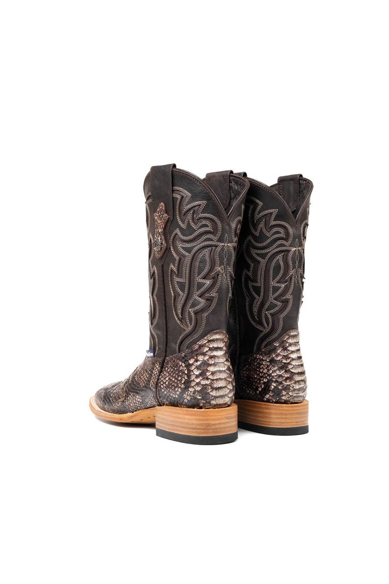 May include: A pair of brown cowboy boots with a snakeskin pattern on the lower portion and decorative stitching on the upper shaft. The boots have a square toe and a stacked heel, showcasing a classic Western style.
