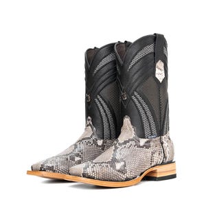 May include: A pair of cowboy boots with a snakeskin pattern on the foot and a black leather upper. The boots have a square toe and a stacked heel. The shaft features decorative stitching and a small emblem.
