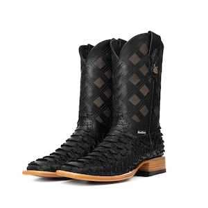 May include: Pair of black cowboy boots with a textured, scaly pattern on the lower part and a diamond-patterned upper. The boots have a square toe and a wooden heel. The brand name "Rockin" is visible on the side.