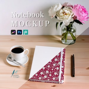 Puede incluir: Un cuaderno blanco con una esquina estampada floral, una taza de café y un bolígrafo sobre una superficie de madera. El cuaderno tiene una banda elástica blanca. La imagen incluye el texto "Notebook MOCKUP". Un jarrón de flores está en el fondo.