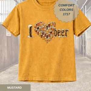 May include: Mustard-colored t-shirt with a graphic that says "I [heart] beer." The heart is formed by various beer glasses. The shirt also has a Comfort Colors 1717 tag.