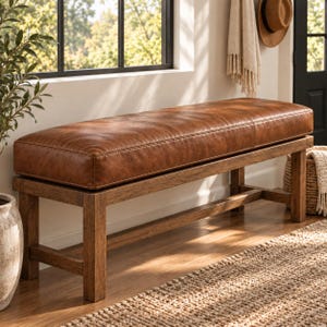 May include: A rectangular bench featuring a thick, tufted brown leather seat cushion supported by a sturdy wooden frame with four straight legs and horizontal support bars connecting the legs on all sides, creating a stable seating structure.