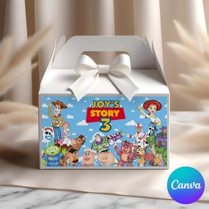 Könnte beinhalten: Weiße Geschenkbox mit Griff und weißer Schleife. Die Vorderseite der Box zeigt eine farbenfrohe Illustration von Charakteren aus dem Film "Toy Story 3" mit dem Text "JOY'S STORY 3".