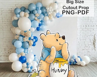 Könnte beinhalten: Ein ausgeschnittener Requisit von Winnie Puuh, der einen Honigtopf mit dem Wort "Hunny" hält. Die Requisite ist von einem Ballonbogen in Blau- und Weißtönen umgeben. Der Text auf dem Bild lautet "18x18, 24x24, 36x36 Big Size Cutout Prop PNG-PDF".