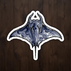 May include: A watercolor-style sticker featuring a dark blue manta ray with a white border. The manta ray has a detailed design with visible brushstrokes, and is set against a dark wood grain background.