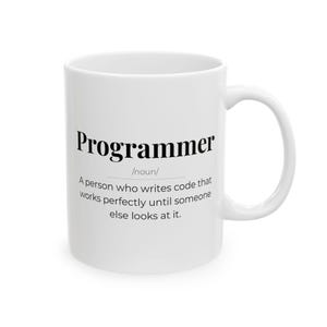 Könnte beinhalten: Weiße Keramik-Tasse mit dem schwarzen Aufdruck "Programmer" und einer Definition. Die Tasse hat einen gebogenen Henkel und ist für Heißgetränke geeignet. Ein humorvolles Geschenk für Programmierer.