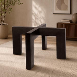 May include: A dark brown, modern coffee table base with a cross-shaped design. The base has four sturdy legs and a minimalist aesthetic, perfect for a living room. The table base is made of wood.
