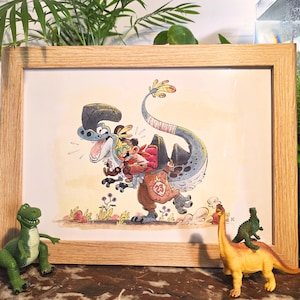 Peut inclure: Illustration encadrée à l'aquarelle d'un dinosaure de dessin animé portant une personne avec un sac. Le dinosaure est bleu et gris, et la personne porte un chapeau. Deux jouets dinosaures sont devant le cadre.
