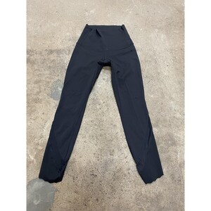 May include: Black athletic leggings with a high waistband. The leggings are made of a smooth, stretchy material and have a streamlined design. The legs taper down to the ankles.