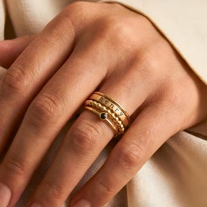 Puede incluir: Un juego de tres tazas de cerámica con un acabado mate moteado. Las tazas son en tonos crema, gris claro y gris oscuro. Cada taza tiene un diseño simple y minimalista y un asa redondeada.