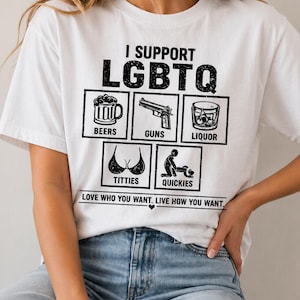 May include: White t-shirt with the text "I SUPPORT LGBTQ" and various graphic icons including beer, a gun, liquor, a bra, and a couple. The shirt also has the text "LOVE WHO YOU WANT. LIVE HOW YOU WANT."