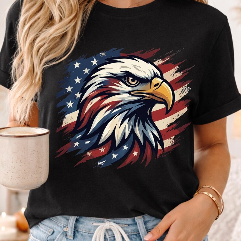 Może przedstawiać: Czarny t-shirt z szczeg&oacute;łową grafiką amerykańskiego bielika w patriotycznych barwach. Głowa orła jest biała, z czerwonymi i niebieskimi akcentami, na tle stylizowanej amerykańskiej flagi. Koszulka jest noszona przez osobę.