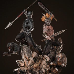 Könnte beinhalten: Detaillierte Statue, die zwei Figuren im Kampf zeigt, eine in einem schwarzen Anzug mit einem Speer, die andere mit orangefarbenem Haar und einer Maske, die ein Schwert schwingt. Der Sockel zeigt knurrende Tierfiguren und felsiges Gelände.