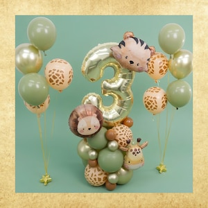 May include: A balloon arrangement featuring a large gold foil number three balloon, surrounded by smaller latex balloons in sage green, metallic gold, and beige with brown giraffe print patterns, plus foil balloons shaped like a tiger, lion, and giraffe.