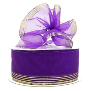 May include: Purple sheer ribbon with gold stripes. The ribbon is rolled on a spool.