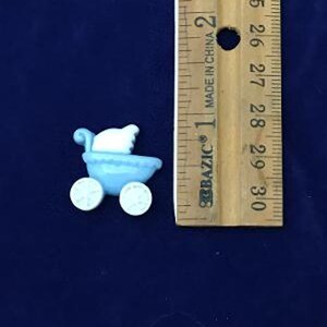 May include: A light blue miniature baby carriage with white accents and wheels. The carriage is next to a wooden ruler, showing its small size. The carriage is approximately 1 inch in length.