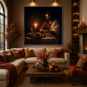 May include: A large framed painting depicts a religious scene with a figure in red and white garments at a table with food and a lit candle. The painting hangs above a beige sectional sofa with orange and brown throw pillows. The room is decorated with candles, pumpkins, and fall foliage.