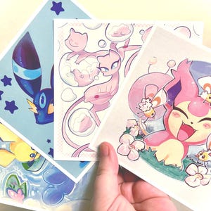 May include: A collection of four square art prints featuring colorful illustrations of cartoon characters. The prints showcase a variety of characters in different poses and settings, with a light color palette and whimsical style.
