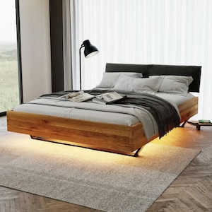 Flytande eksäng med stoppad huvudgavel, massivt trä och metall, industriellt modern