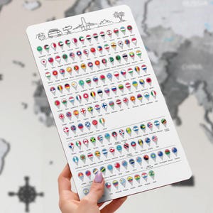 Könnte beinhalten: Eine weiße, rechteckige Tischset mit einer Weltkarte und Länderflaggen in einem Pin-Design. Die Oberseite des Tischsets zeigt Illustrationen zum Thema Reisen. Das Tischset wird von einer Person gehalten.