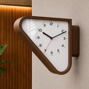 May include: A wall-mounted clock with a brown, triangular-shaped frame and a white face. The clock features black hour and minute hands, a thin red second hand, and black numerical markers from 1 to 12 arranged in a circular pattern.