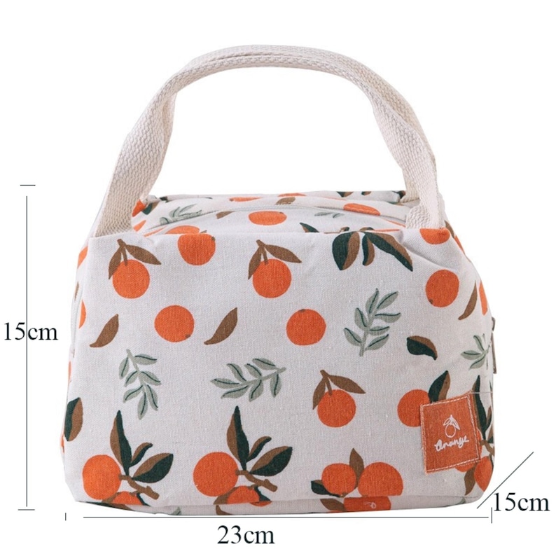 May include: A rectangular lunch bag with a white base and an orange fruit pattern featuring green leaves. The bag has two top handles and a small square label with the text "orange". It measures 23 cm in width, 15 cm in height, and 15 cm in depth.