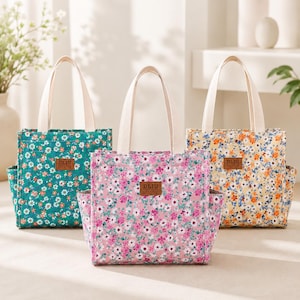 May include: Three tote bags with two cream-colored handles each, featuring a floral pattern in green, pink, and yellow. Each bag has a brown rectangular patch on the front with the text DLIU FASHION and side pockets on the left and right sides.
