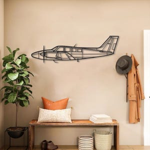 May include: A black metal airplane wall art piece. The artwork depicts the outline of a small airplane with a propeller and detailed windows. The art is mounted on a beige wall, adding a touch of aviation-themed decor to the space.