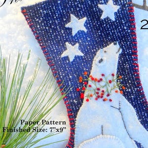 May include: A blue Christmas stocking with white stars and a polar bear design. The stocking is trimmed in red and features the text "Thank you Friends" and "2021". Finished size is 7"x9".