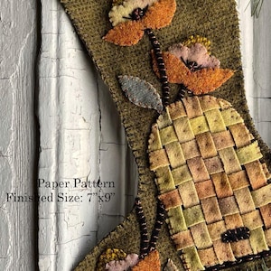 May include: A handmade Christmas stocking with a bee and floral design. The stocking is olive green with a woven beehive, orange and pink flowers, and a yellow and black bee. The finished size is 7" x 9".