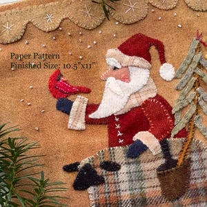 May include: A Christmas-themed fabric art piece featuring Santa Claus riding a sheep, holding a bird and a Christmas tree. The finished size is 10.5"x11". The artwork is in shades of red, brown, and beige, with a scalloped edge.