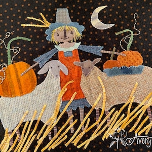 以下が含まれることがあります： カカシ、羊2匹、カボチャを描いた秋をテーマにしたテキスタイルアート作品。カカシは青い帽子とオレンジ色のオーバーオールを着ています。羊はライトグレーとタンで、カボチャはオレンジ色です。背景は茶色の水玉模様の黒です。