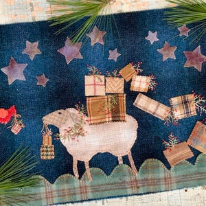 May include: A blue textile with a sheep carrying gifts, a red bird, and star shapes. The sheep has a stack of presents on its back and is holding a gift in its mouth. The background has star shapes in various sizes.