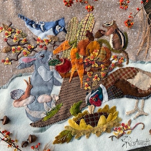 Puede incluir: Una obra de arte textil afieltrada que presenta una cornucopia rebosante de elementos de la cosecha de otoño. Se representan un arrendajo azul, un conejo, una ardilla listada y un faisán entre zanahorias, maíz y flores. La obra está adornada con bellotas y bayas.